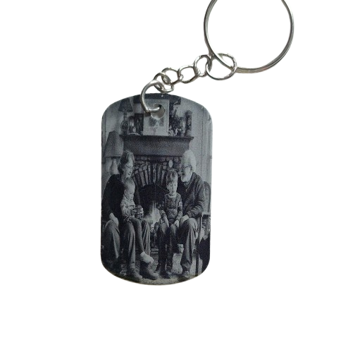 Keychain with a black and white photo of a family by a fireplace on a white background